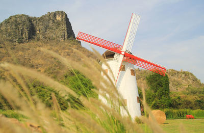 Traditional windmill on mountain against sky