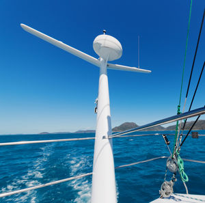 Sailboat in sea against clear blue sky