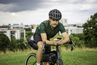 Man using smart phone while sitting on bicycle