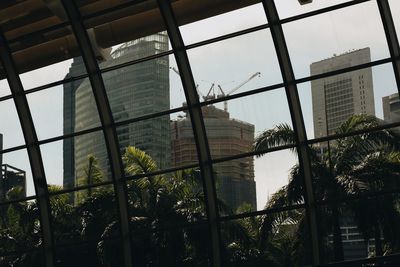 Low angle view of buildings seen through glass window