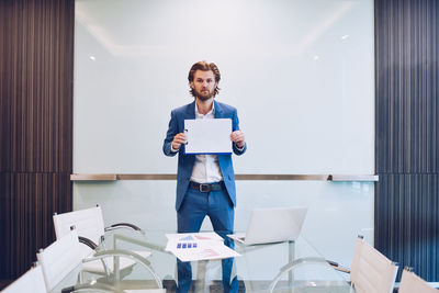 Portrait of businessman standing in conference room