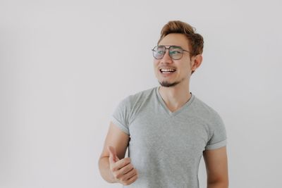 Portrait of young man standing against white background