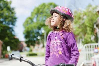 Girl in safety helmet standing in street