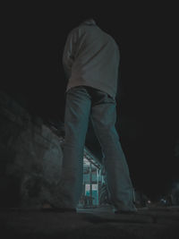 Low angle view of man standing against sky at night