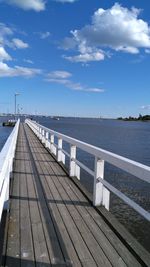 Bridge over river against cloudy sky