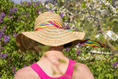 Portrait of woman from the back wearing hat in the spring garden