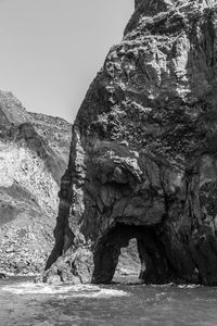 Rock formation in sea against clear sky