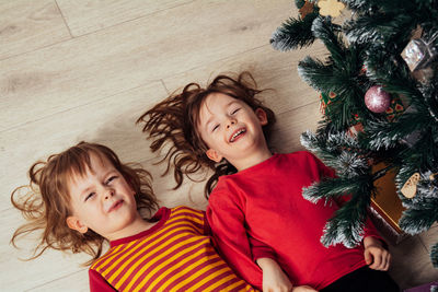 Happy funny children lying on the floor next to the christmas tree. christmas holiday