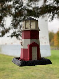 Close-up of birdhouse on field against trees in park