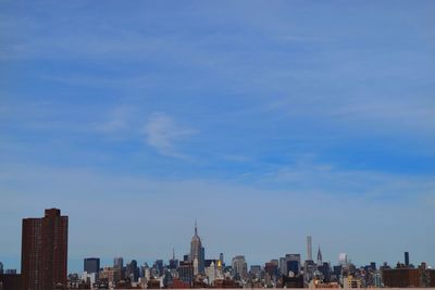 Buildings in city against blue sky