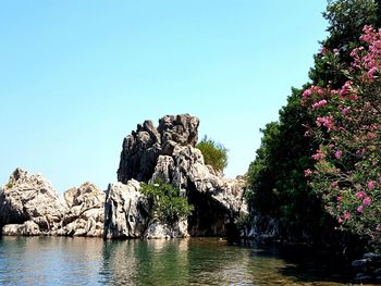 Low angle view of rock formation against clear blue sky
