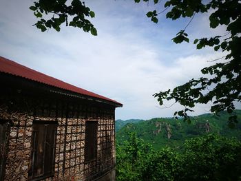 Built structure by trees against sky