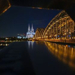 Illuminated buildings by river at night