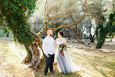 Couple standing near tree in forest