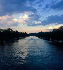 Scenic view of river against sky at sunset