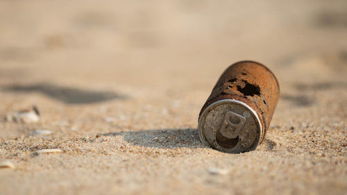 Close-up of metallic object on sand