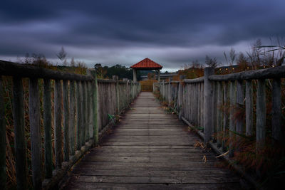 View of wooden footbridge against sky