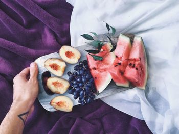 Close-up of hand holding fruit platter
