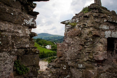 Stone wall of old building against sky