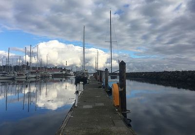 View of marina in lake against cloudy sky