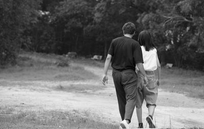 Rear view of couple walking on land