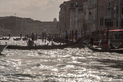 People on boats in grand canal against buildings