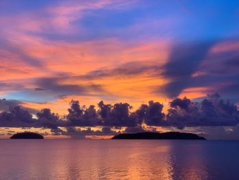 Scenic view of sea against dramatic sky during sunset