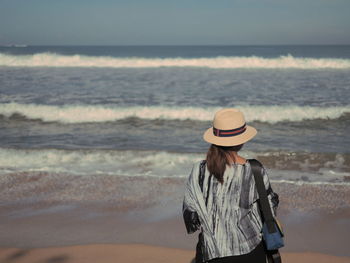 Rear view of woman standing on beach