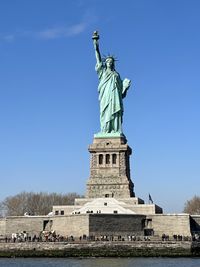 Low angle view of statue against clear blue sky