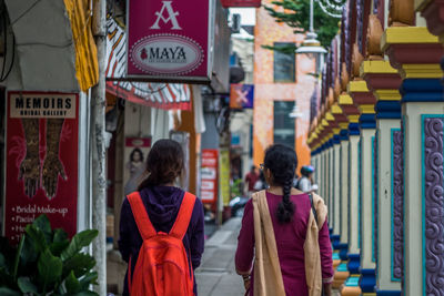 Rear view of people walking in front of building