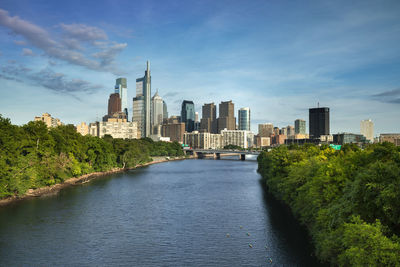 River amidst buildings in city against sky