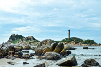 Rocks by sea against sky