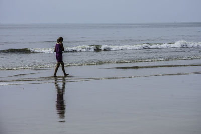Rear view of girl walking on beach