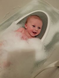 Cute baby boy bathing at home