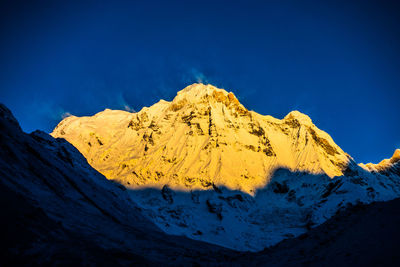 Scenic view of snowcapped mountains against clear blue sky