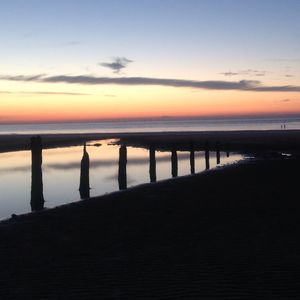 Pier on sea at sunset