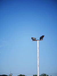 Low angle view of floodlight against clear blue sky