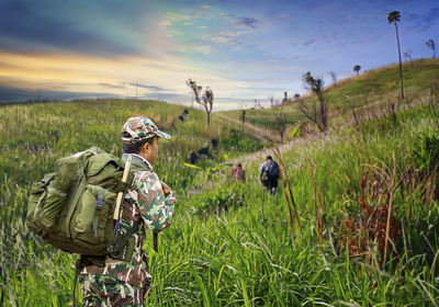 People walking on field against sky
