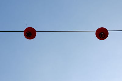 Low angle view of red light against clear sky