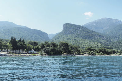 Scenic view of river by mountains against sky