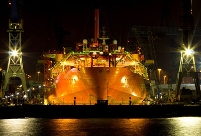 Illuminated harbor against sky at night