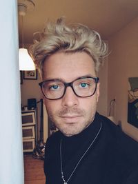 Portrait of young man wearing eyeglasses at home