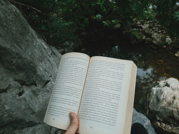 Midsection of person holding book