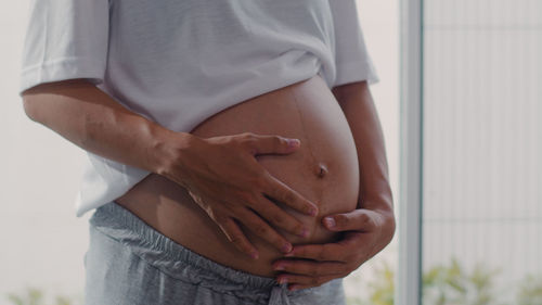 Midsection of man pregnant woman touching belly