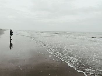 Teenage girl standing on shore against sea at beach