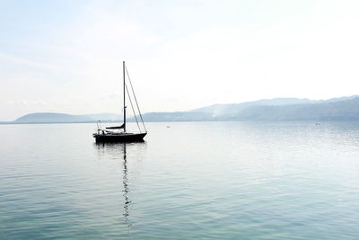 Sailboat sailing on sea against sky