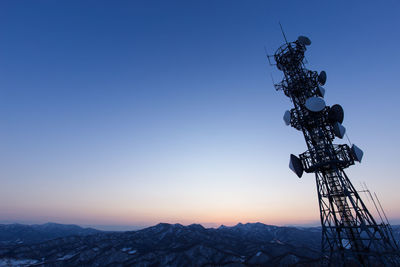 Low angle view of communication tower against clear sky at dusk