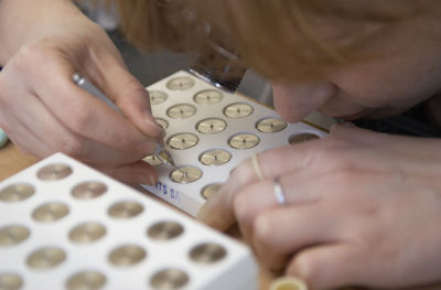 High angle view of woman working on wristwatch machine