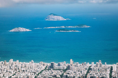 High angle view of cityscape by sea against sky