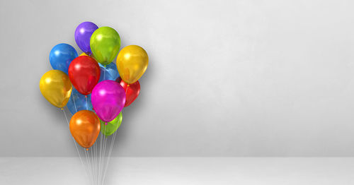 Close-up of multi colored balloons against wall